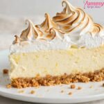 Slice of Gordon Ramsay lemon meringue cheesecake with torched meringue peaks