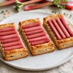 Golden puff-pastry rhubarb tart with pink rhubarb rows on a white plate