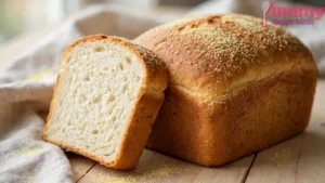 Golden homemade white bread loaf with semolina-dusted crust on a wooden board