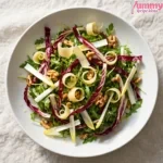 Overhead view of Italian rocket salad with arugula, radicchio, endive, toasted walnuts, and shaved Parmesan in a white bowl